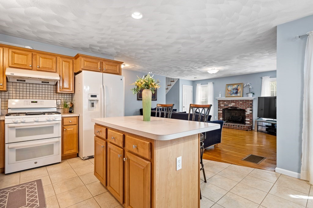 2 Gerry Drive, Unit 2 Hudson, MA 01749 - Photo 8 of 41 a view of a kitchen with kitchen island a counter top space a sink a refrigerator and a window