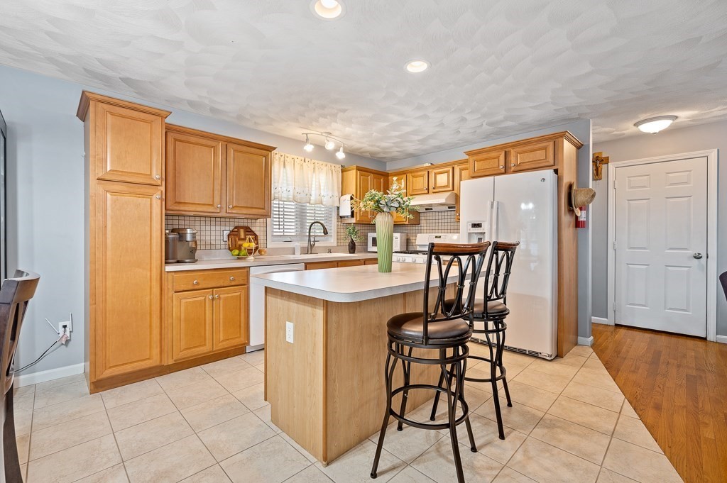 2 Gerry Drive, Unit 2 Hudson, MA 01749 - Photo 9 of 41 a kitchen with a table chairs refrigerator and cabinets