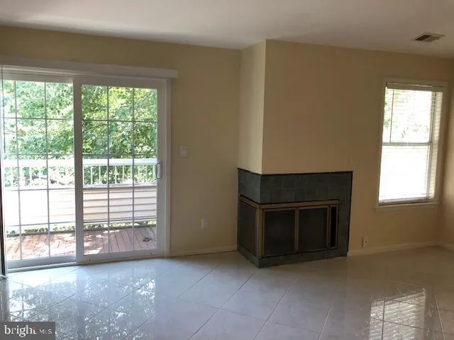 a view of an empty room with a fireplace and a window