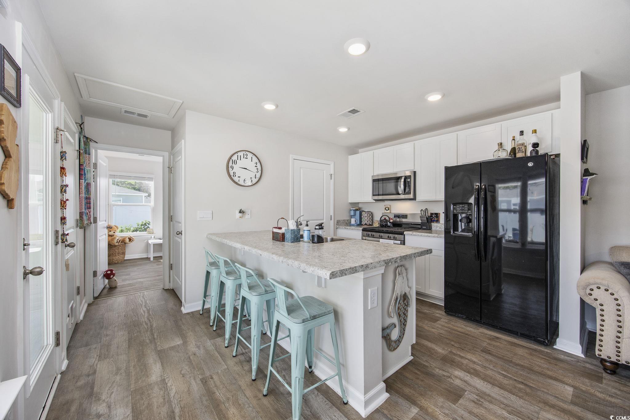 924 Akron Street Conway, SC 29526 - Photo 14 of 37 Kitchen with stainless steel appliances, white cabinetry, dark wood-type flooring, light countertops, and recessed lighting