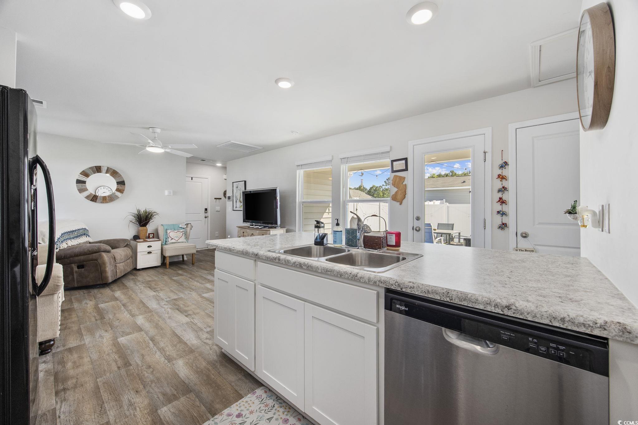 924 Akron Street Conway, SC 29526 - Photo 36 of 37 Kitchen featuring stainless steel dishwasher, a sink, open floor plan, freestanding refrigerator, and white cabinets
