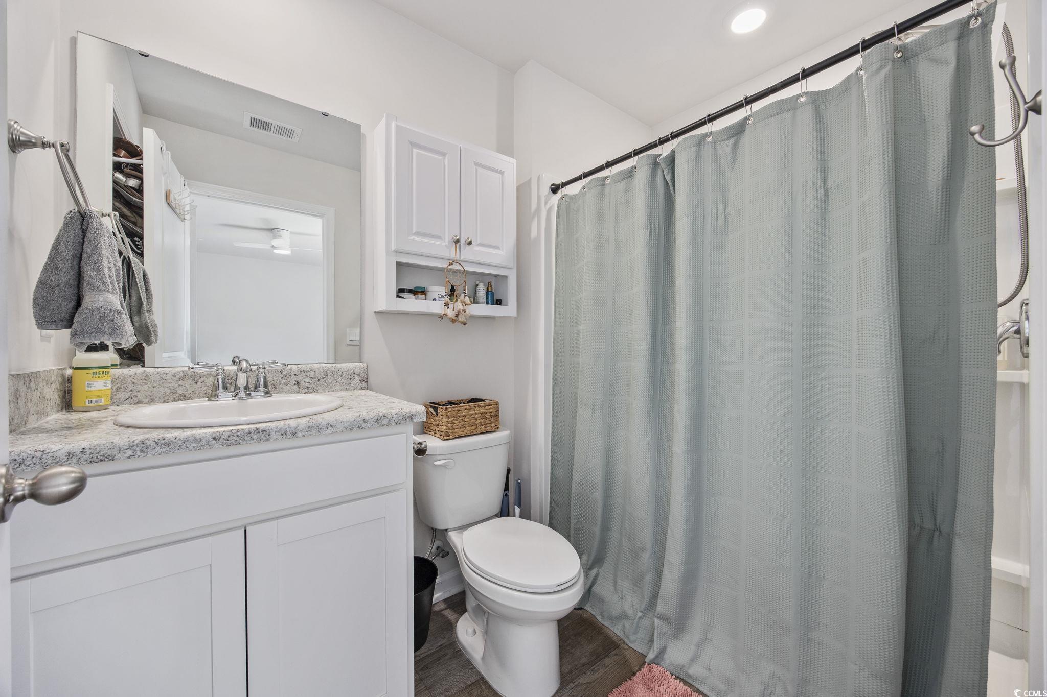 924 Akron Street Conway, SC 29526 - Photo 20 of 37 Full bath with toilet, vanity, wood finished floors, and curtained shower