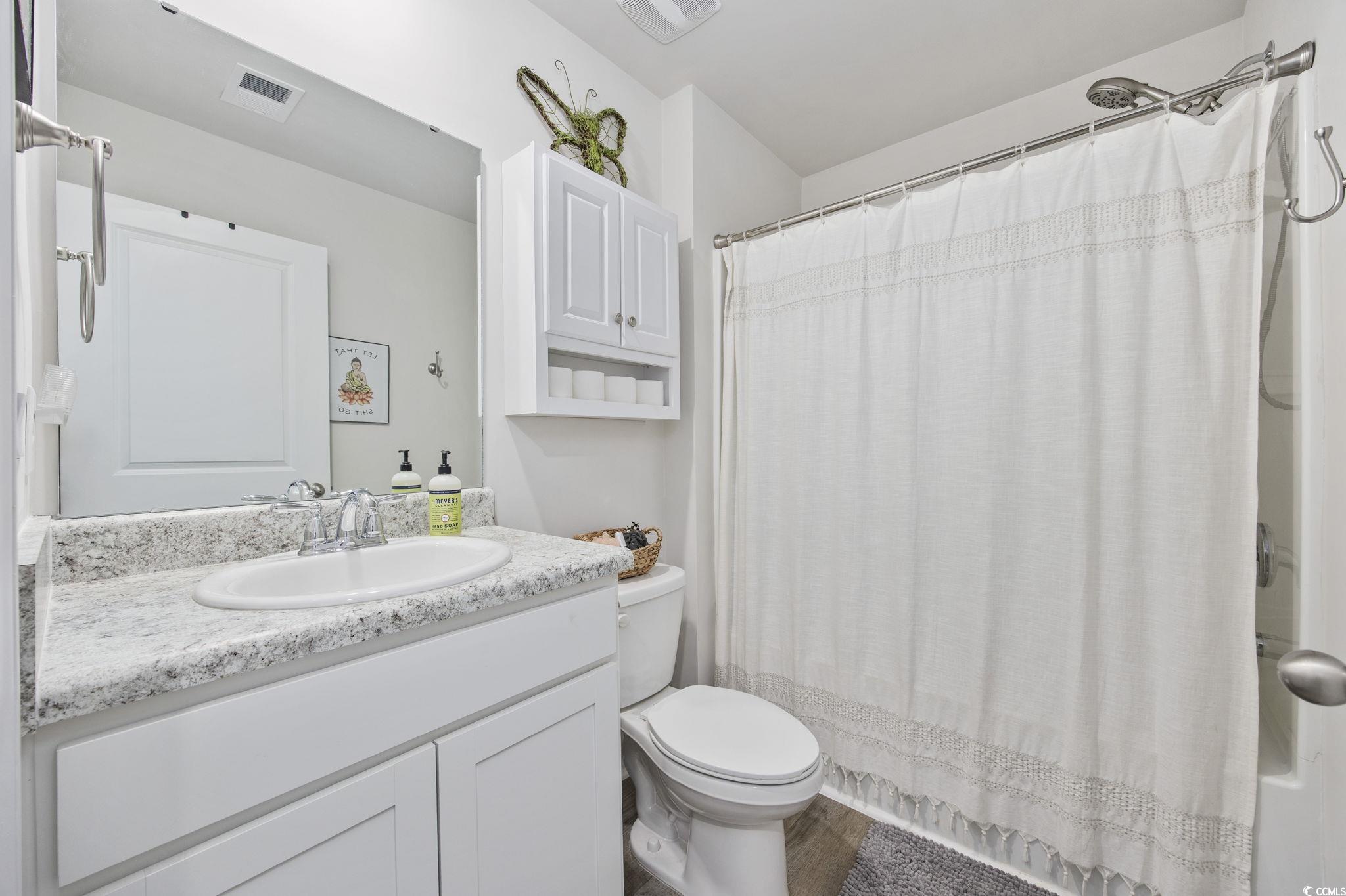 924 Akron Street Conway, SC 29526 - Photo 7 of 37 Bathroom featuring vanity, toilet, wood finished floors, and shower / bath combo with shower curtain