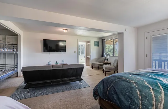 a spacious bedroom with a bed and a flat screen tv