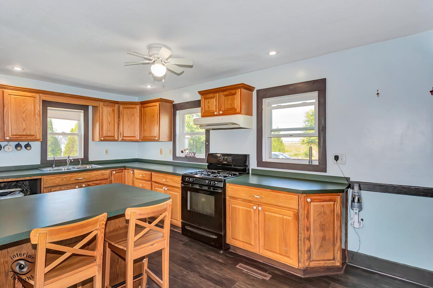 1258 East 2900 North Road Clifton, IL 60927 - Photo 8 of 38 a kitchen with granite countertop a stove a sink and a microwave