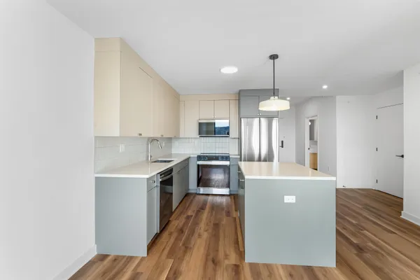 a kitchen with a refrigerator a stove top oven a sink dishwasher and a refrigerator with wooden floor