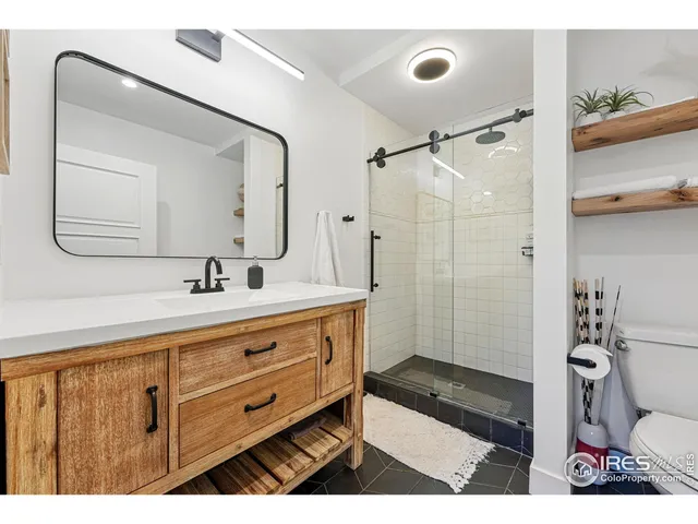 a spacious bedroom with a bed a couch and a potted plant