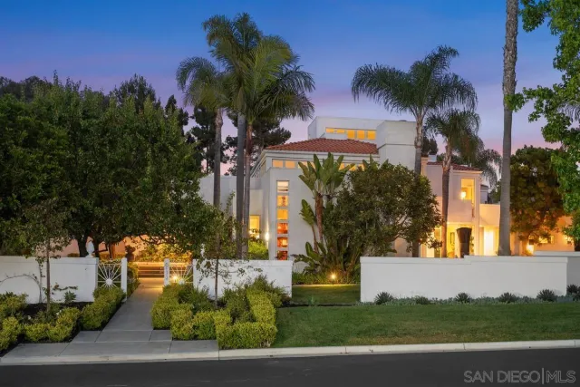 a view of a house with a yard and palm trees