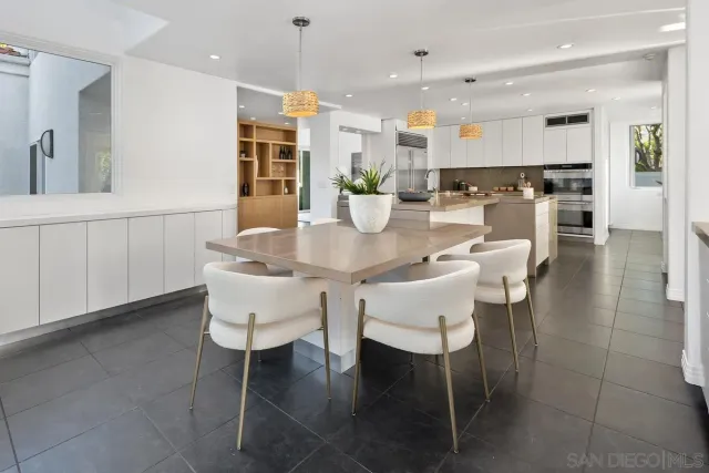 a dining room with stainless steel appliances kitchen island granite countertop a dining table chairs and view kitchen