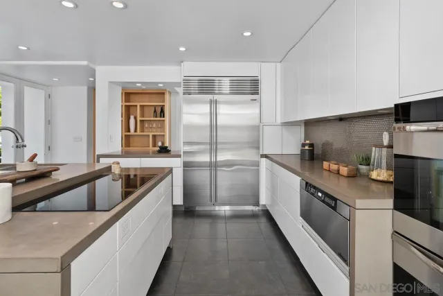 a kitchen with a refrigerator a sink and white cabinets