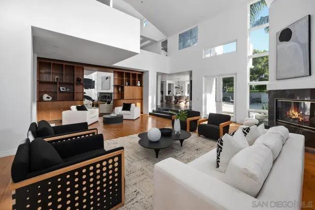 a living room with furniture a fireplace and a large window