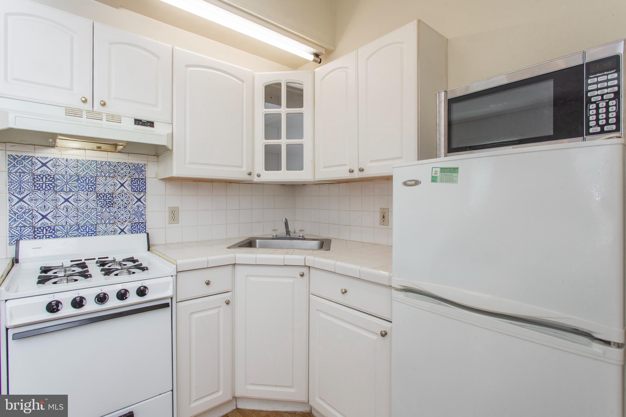 1807 Spruce Street, Unit 2F Philadelphia, PA 19103 - Photo 7 of 17 a kitchen with granite countertop a sink a stove and cabinets