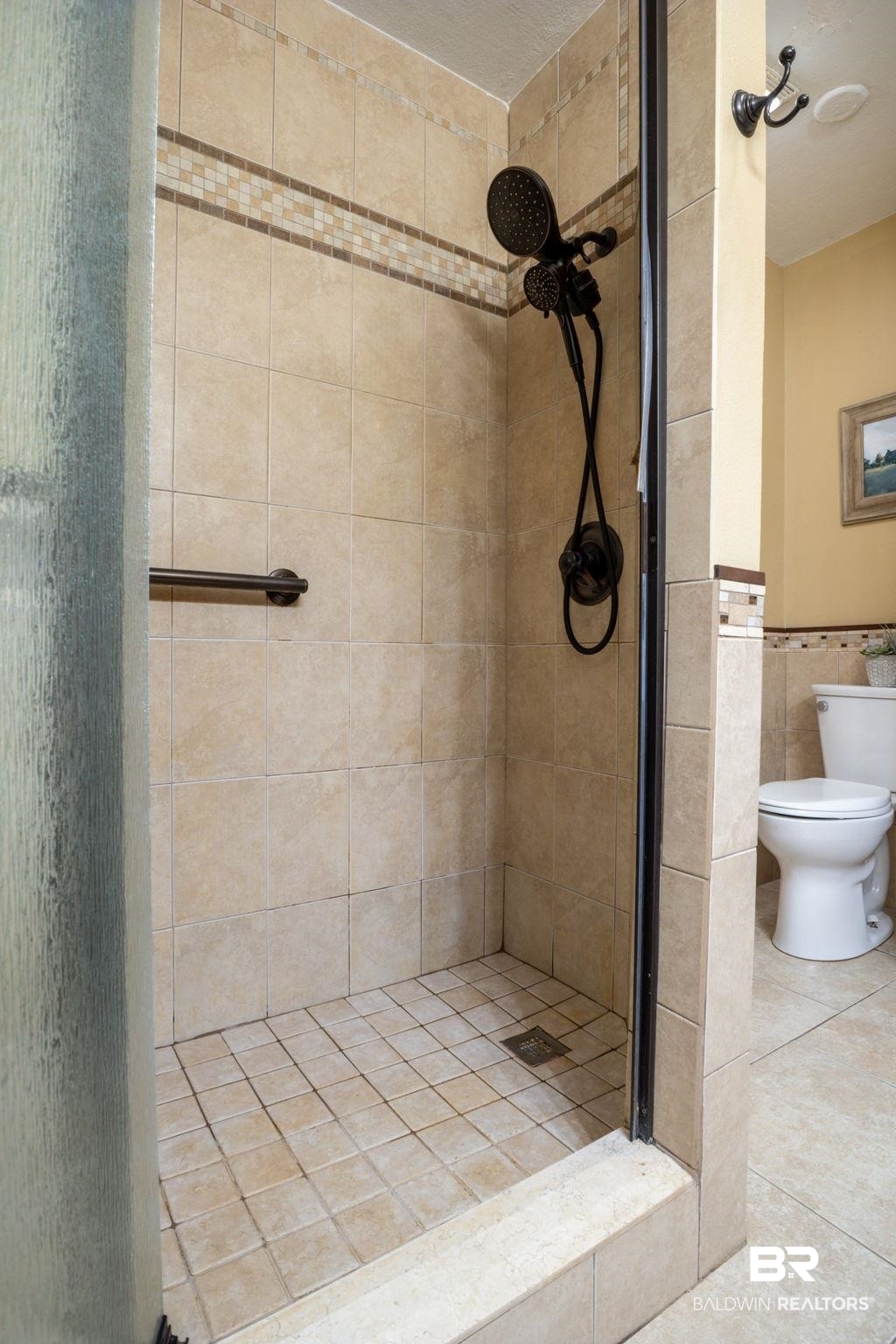 32345 River Lake Road Seminole, AL 36574 - Photo 28 of 56 Full bath featuring tile patterned floors, tile walls, toilet, a shower stall, and a wainscoted wall