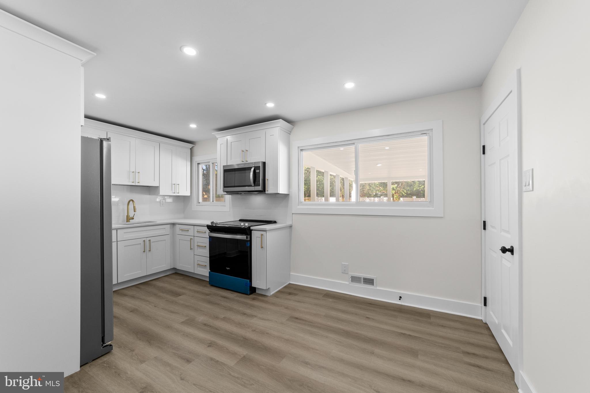 100 Colwick Drive Somers Point, NJ 08244 - Photo 2 of 30 a kitchen with granite countertop white cabinets and wooden floor
