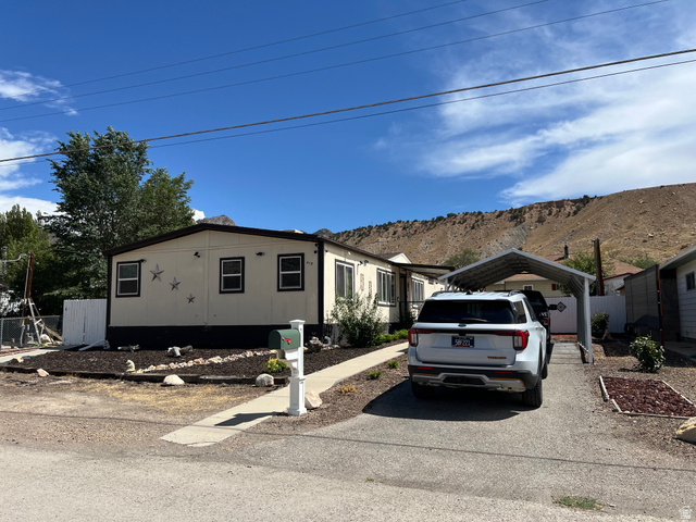 419 2nd E Street Helper, UT 84526 - Photo 36 of 36 Single-story residence featuring a carport, front yard landscaping with rock accents, and a paved driveway