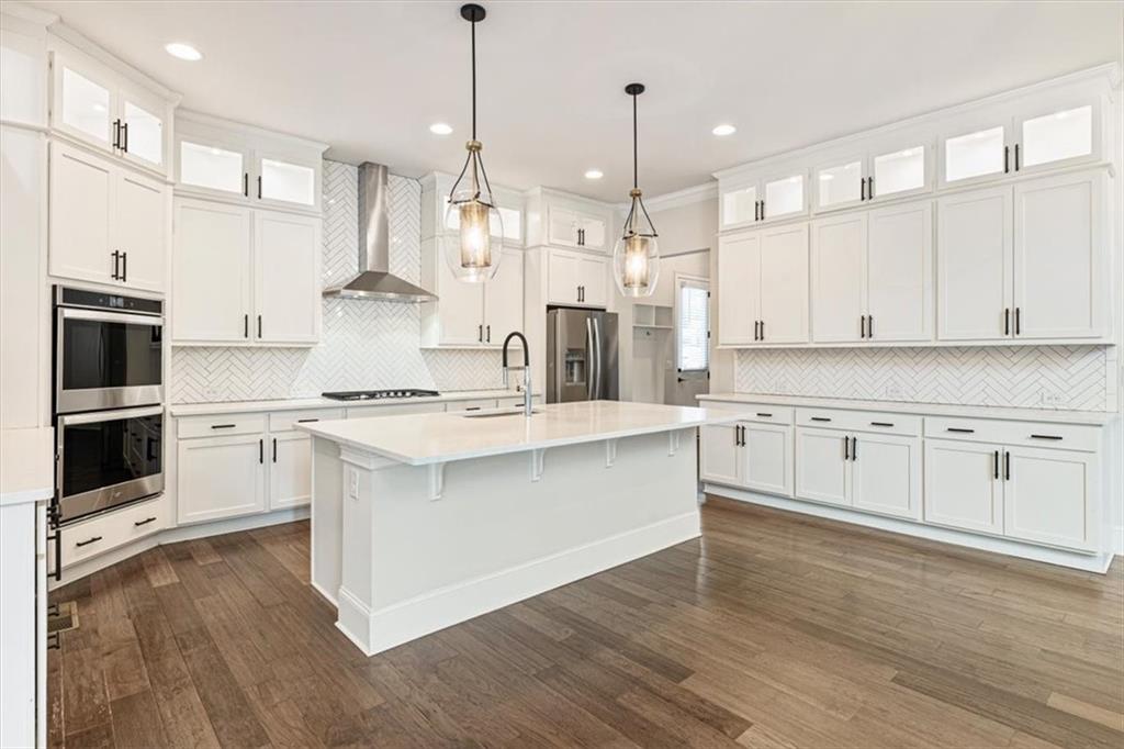 947 Hunter Way Milton, GA 30004 - Photo 30 of 78 a large kitchen with cabinets and wooden floor