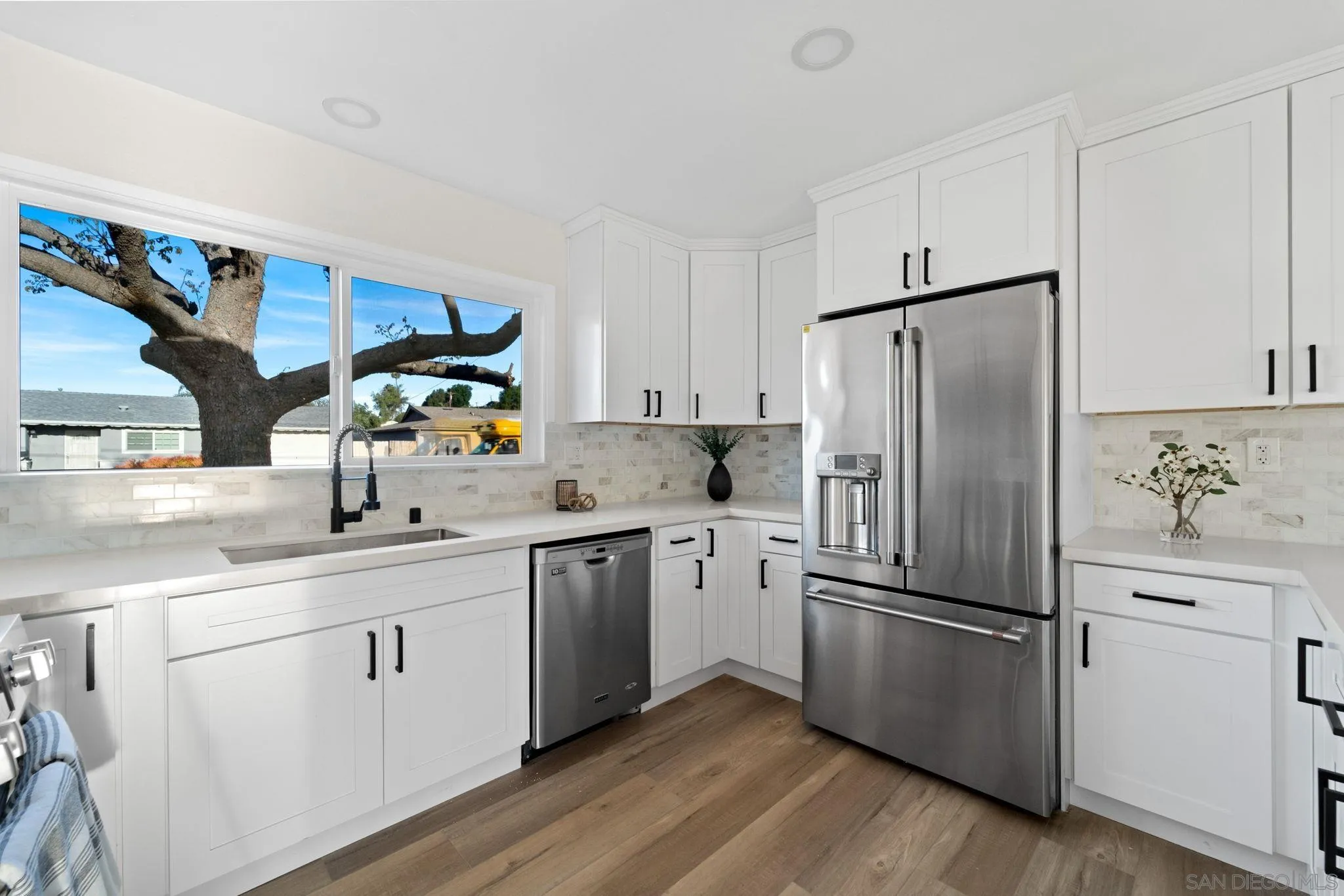 9511 Nicole Way Santee, CA 92071 - Photo 11 of 27 a kitchen with a refrigerator sink and white cabinets