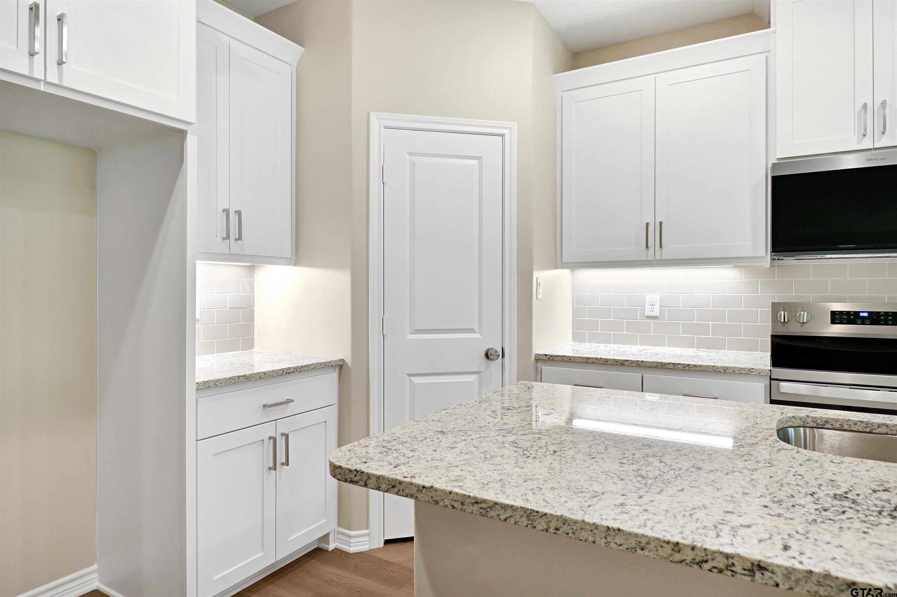 3053 Guinn Farms Road Tyler, TX 75707 - Photo 8 of 32 a kitchen with stainless steel appliances granite countertop a sink and a stove