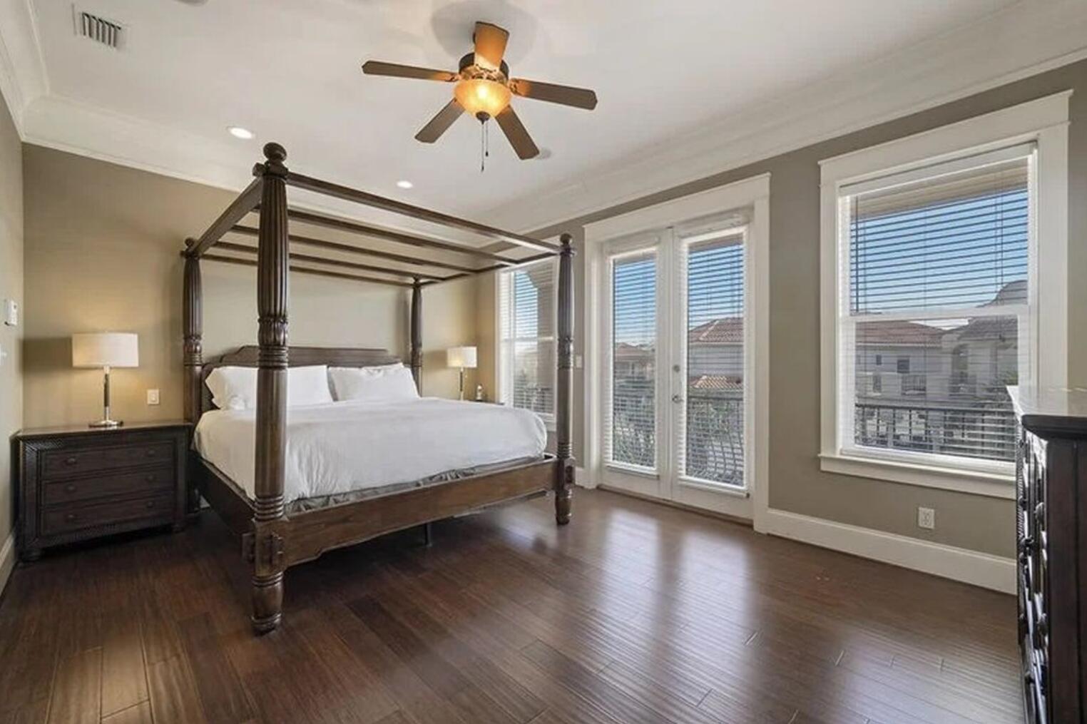 4836 Ocean Boulevard Destin, FL 32541 - Photo 10 of 44 a bedroom with a large bed and a chandelier fan