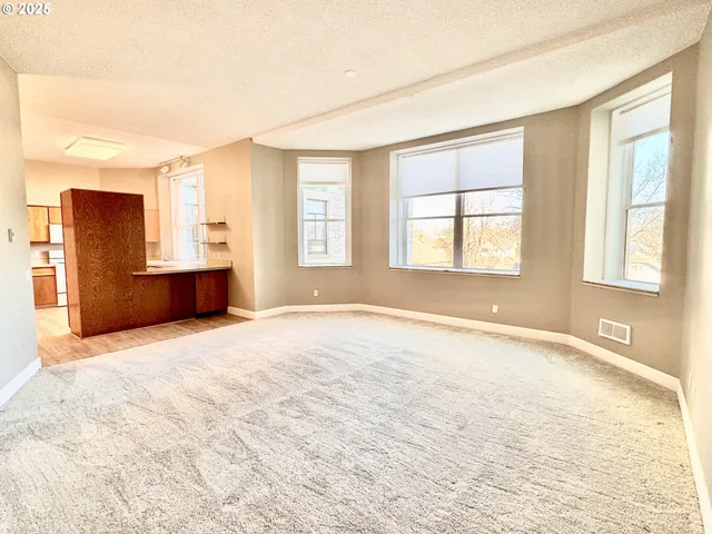 an empty room with windows and closet