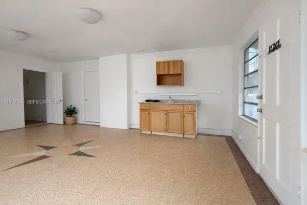 a view of an empty room with a fireplace and a window