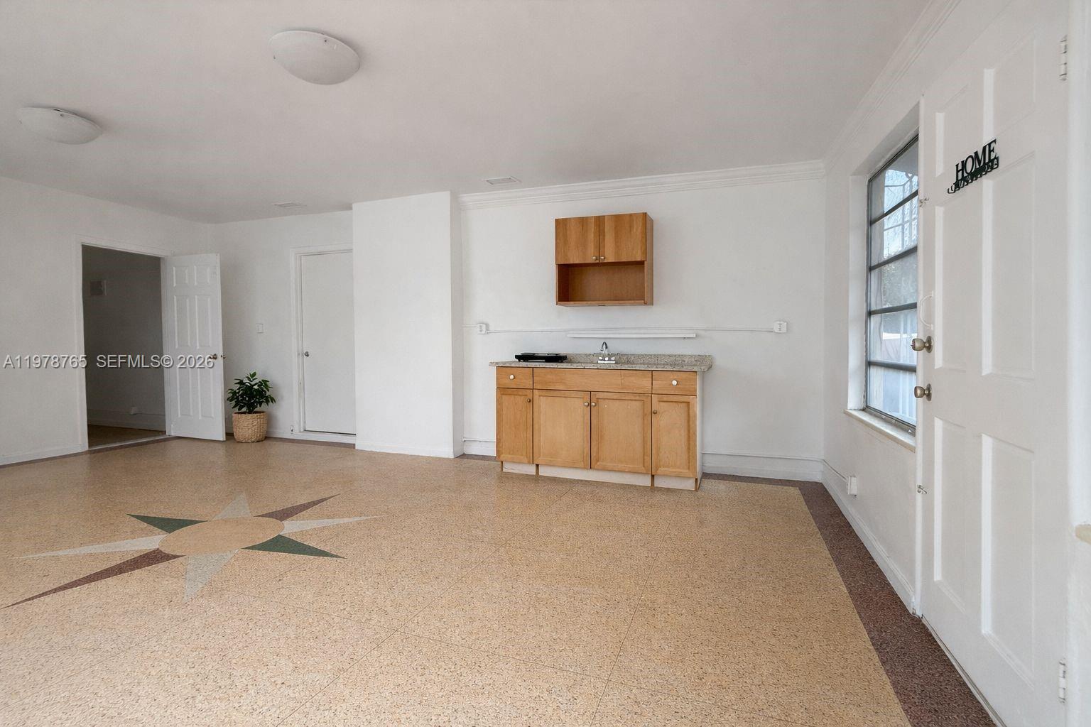 2227 Southwest 2nd Terrace, Unit 2227 Miami, FL 33135 - Photo 4 of 10 a view of an empty room with a fireplace and a window