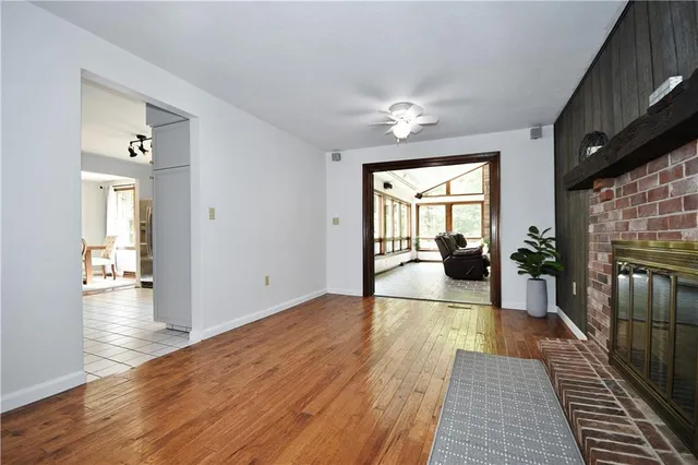 a view of a living room with wooden floor and a fireplace