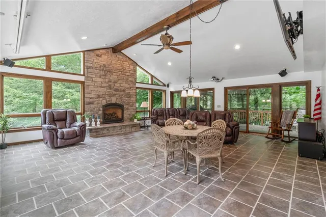 a living room with furniture a fireplace and a floor to ceiling window
