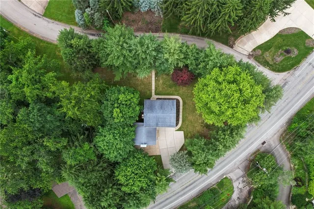 an aerial view of a house with a yard and large trees