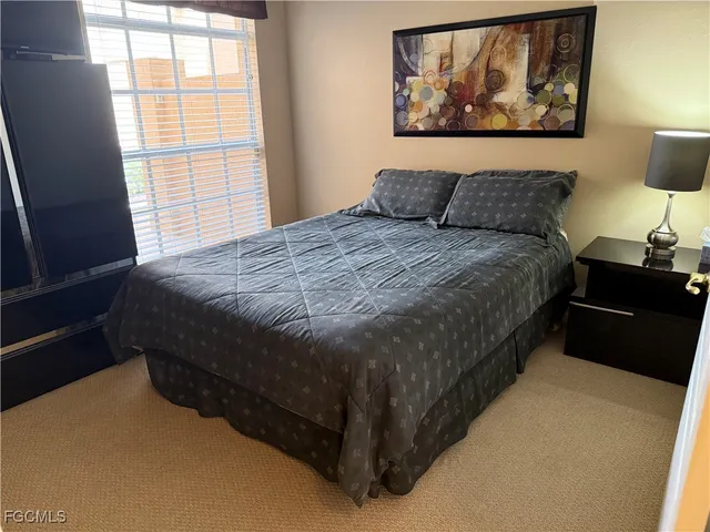a living room with furniture a flat screen tv and floor to ceiling window