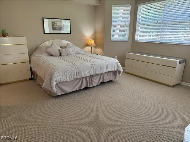 a bedroom with a bed mirror and window