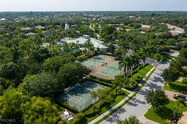 an aerial view of a house with a yard and large trees