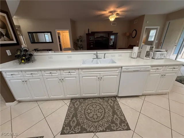 a kitchen with white cabinets a sink stove and refrigerator