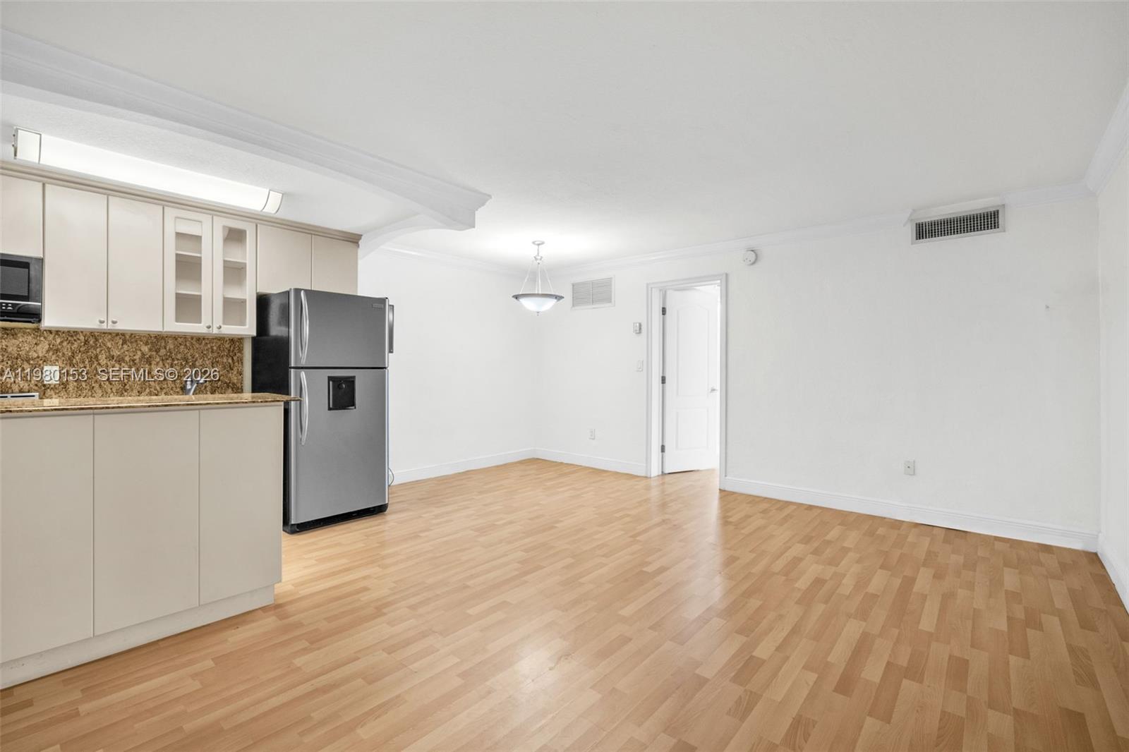 a view of kitchen with refrigerator cabinets and wooden floor