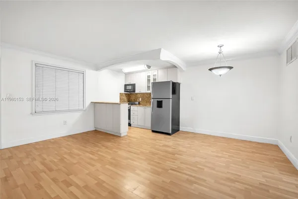 a view of a kitchen with a refrigerator and a sink
