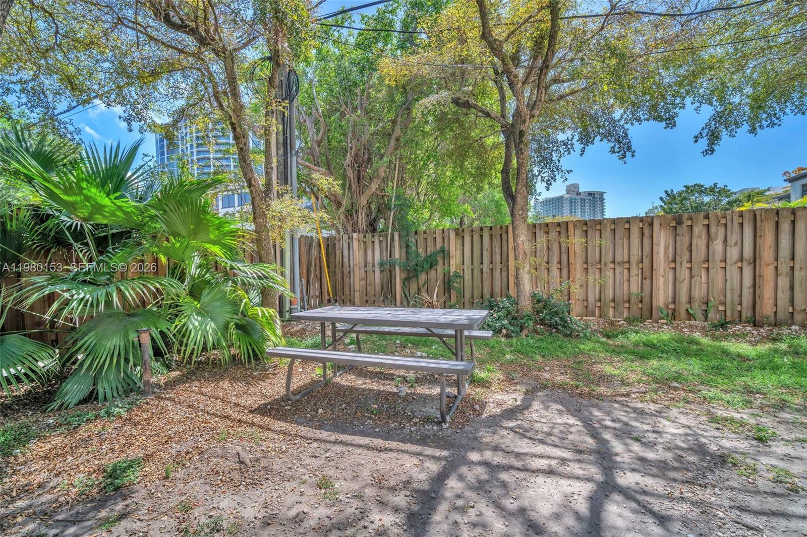 3245 Virginia Street, Unit 39 Miami, FL 33133 - Photo 19 of 25 a wooden bench sitting in the middle of a backyard