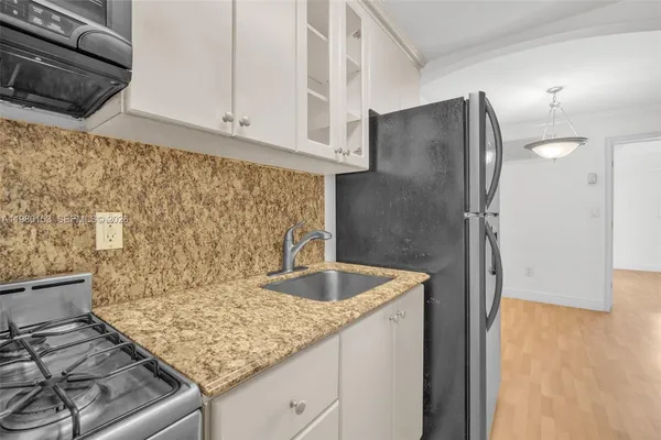 a kitchen with granite countertop cabinets stainless steel appliances and a sink
