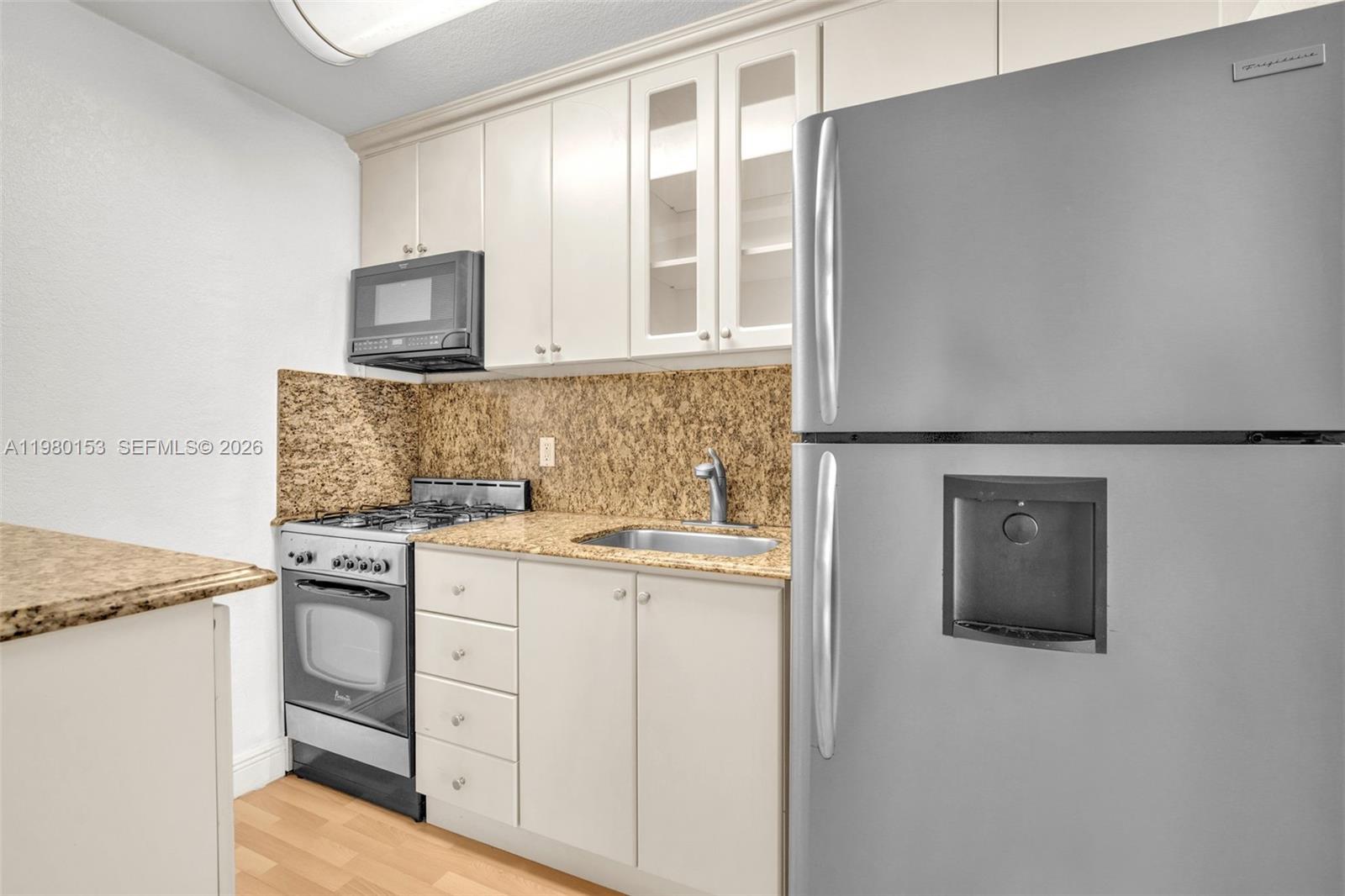 3245 Virginia Street, Unit 39 Miami, FL 33133 - Photo 10 of 25 a kitchen with granite countertop cabinets stainless steel appliances and a sink