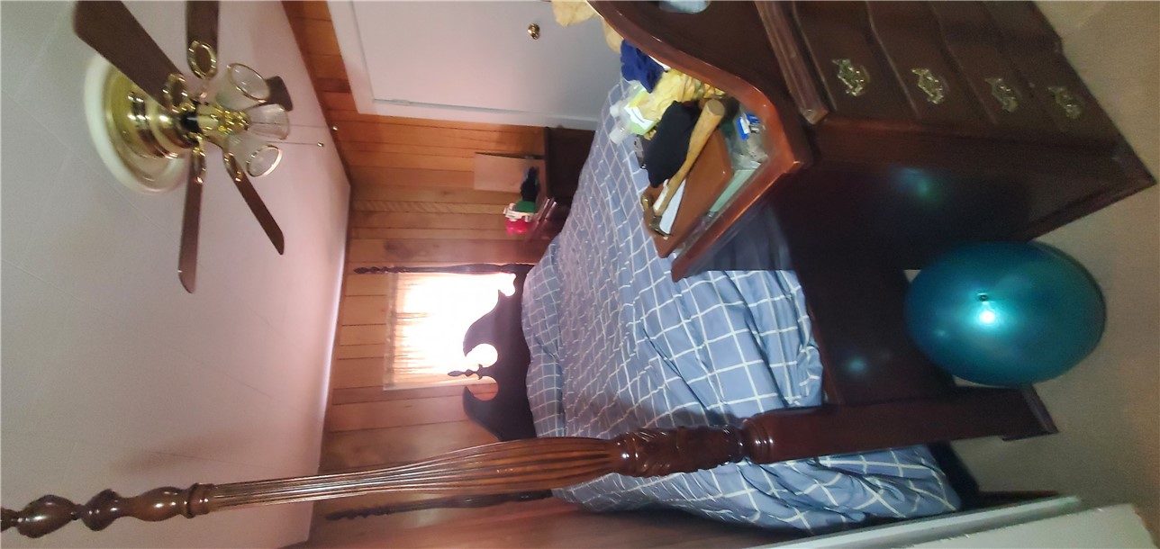 114 Hampton Street Pelzer, SC 29669 - Photo 11 of 21 This cozy bedroom features paneling and a ceiling fan, creating a comfortable retreat.