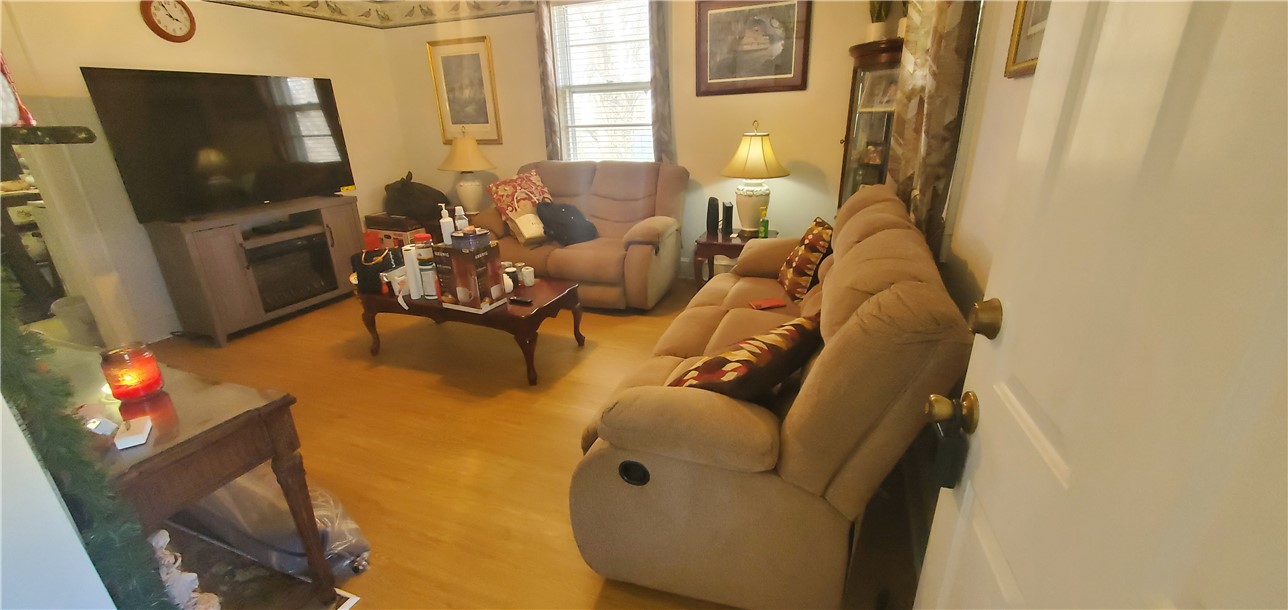 114 Hampton Street Pelzer, SC 29669 - Photo 15 of 21 This inviting living room features warm wood flooring, offering a comfortable and welcoming space for everyday living.