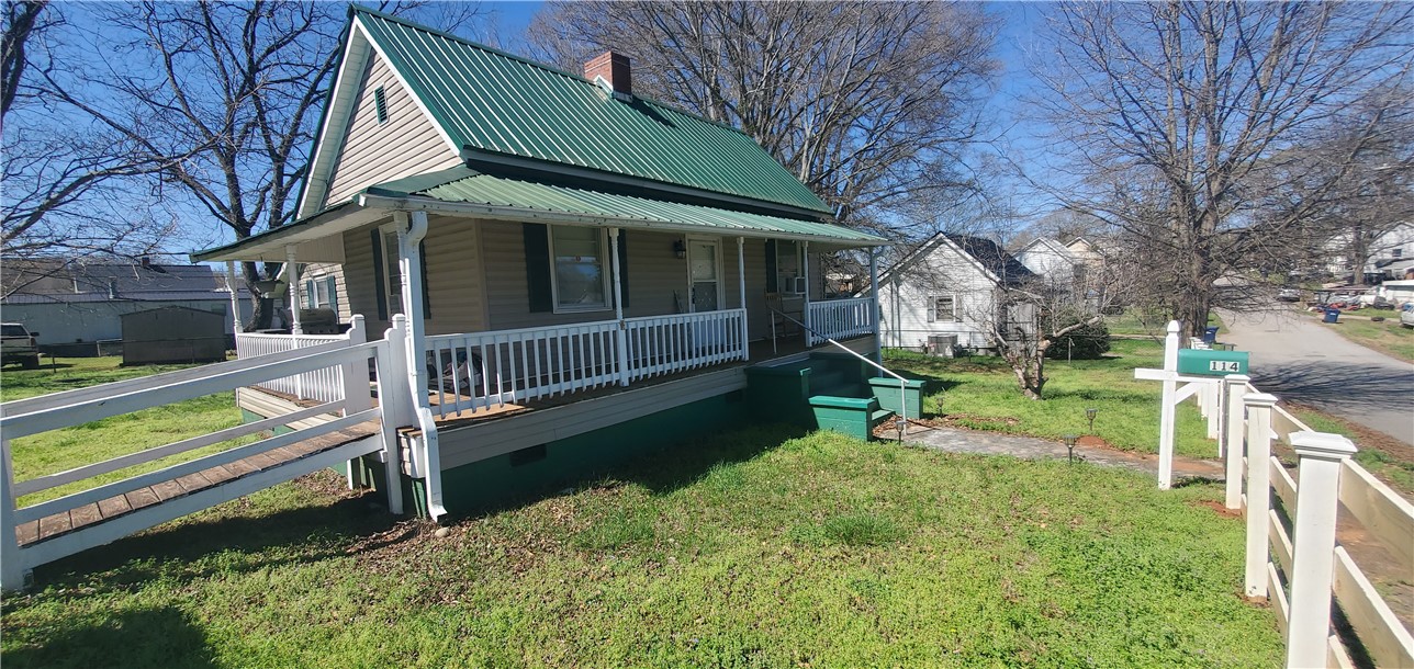 114 Hampton Street Pelzer, SC 29669 - Photo 3 of 21 This quaint home features a welcoming front porch and a lush green yard.