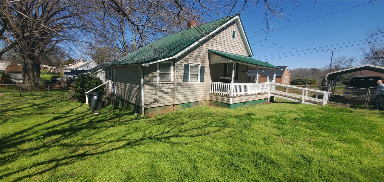 114 Hampton Street Pelzer, SC 29669 - Photo 4 of 21 This inviting residence features a verdant lawn and a welcoming front porch with an accessible ramp.