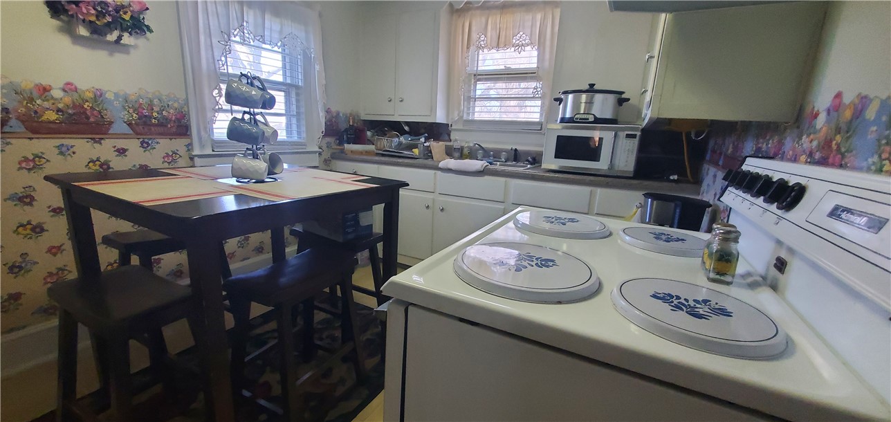 114 Hampton Street Pelzer, SC 29669 - Photo 7 of 21 This cozy kitchen features a practical layout, bright windows, and classic appliances for comfortable living.