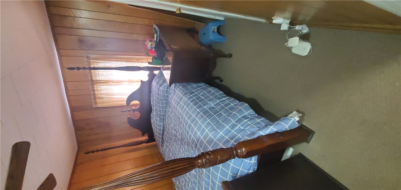 114 Hampton Street Pelzer, SC 29669 - Photo 10 of 21 This cozy bedroom features warm wood paneling and a comfortable carpeted floor.