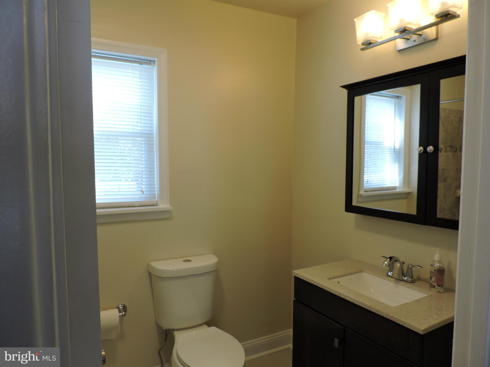 3911 Annapolis Road Halethorpe, MD 21227 - Photo 13 of 24 a bathroom with a toilet sink and mirror