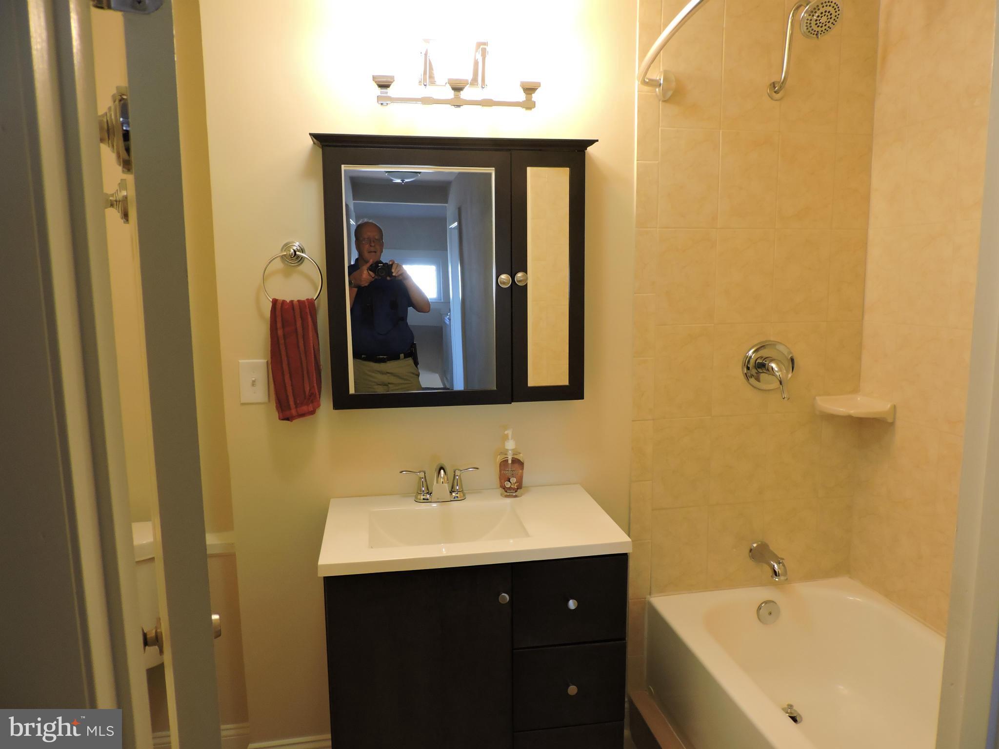 3911 Annapolis Road Halethorpe, MD 21227 - Photo 15 of 24 a bathroom with a bathtub sink and mirror