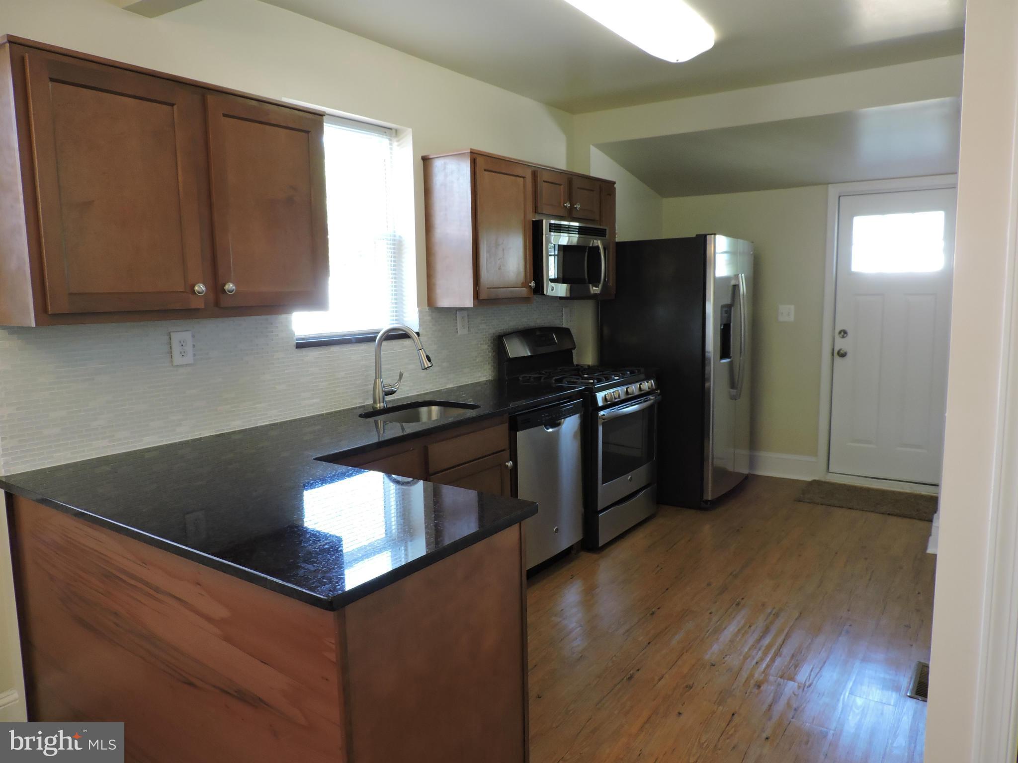 3911 Annapolis Road Halethorpe, MD 21227 - Photo 6 of 24 a kitchen with stainless steel appliances granite countertop a sink a stove and a refrigerator