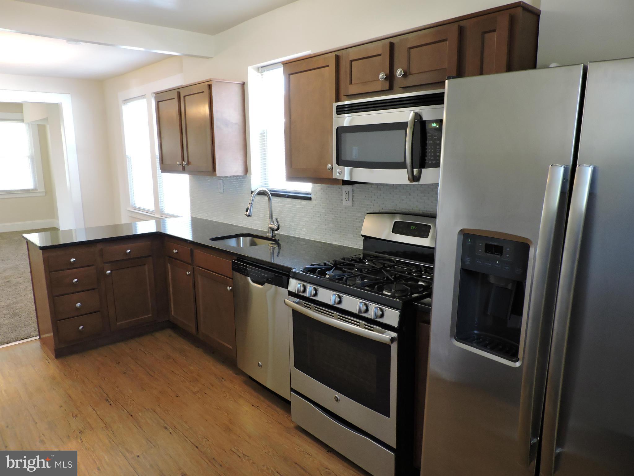 3911 Annapolis Road Halethorpe, MD 21227 - Photo 7 of 24 a kitchen with stainless steel appliances granite countertop a stove microwave and refrigerator
