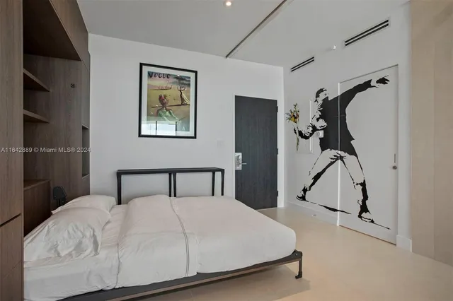 a bedroom with a bed and a painting on the wall