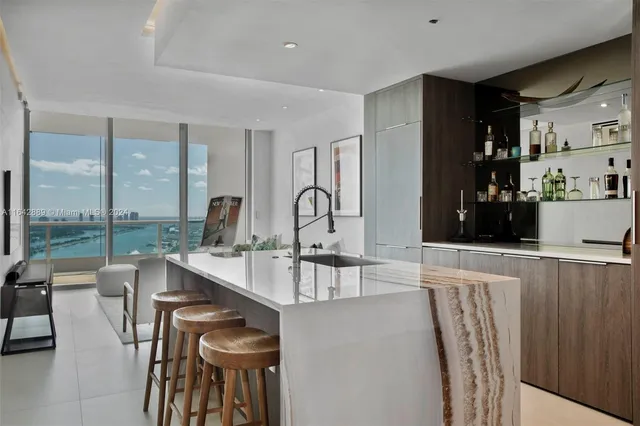 a room with stainless steel appliances kitchen island granite countertop furniture and a view of living room